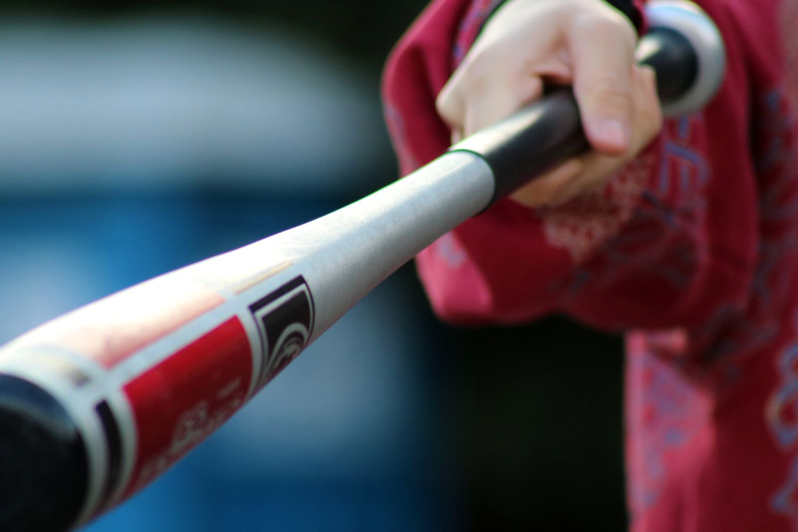 Hands gripping an aluminum baseball bat