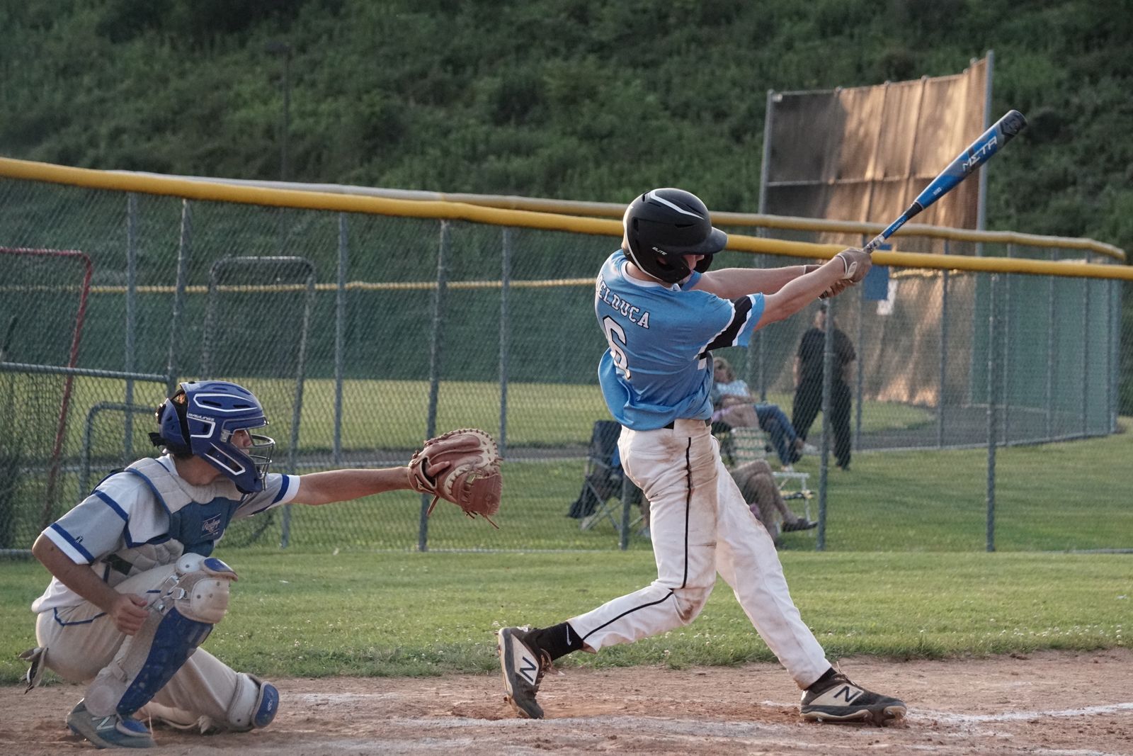 Youth hitter at contact, filmed from the open side with the whole body and bat in frame